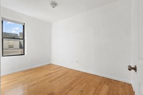 East Orange apartment for rent - A room with a wooden floor and a white door.