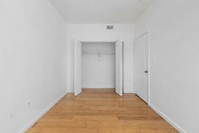 East Orange apartment for rent - A room with white walls and wooden flooring with a doorway leading to another room.