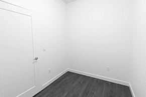Edmonton apartment for rent - a bedroom with white walls and wood floors and a door