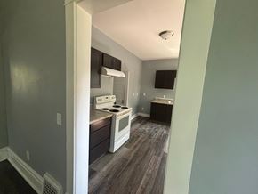 Akron house for rent - A kitchen with white appliances and wood flooring.