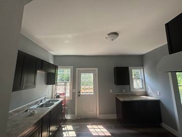 Akron house for rent - A kitchen with a sink, stove, and countertop.