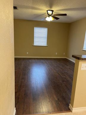 Snyder house for rent - A room with a ceiling fan and wooden flooring.