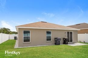 Winter Haven house for rent - a small brown house with a grass yard and a white fence