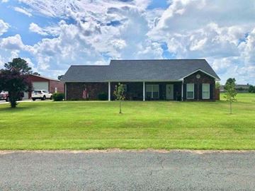 Leesville house for rent - a house with a green lawn and a cloudy sky