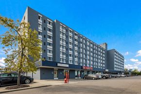 Madison Heights apartment for rent - A large grey building with a blue sign on the front.