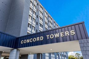 Madison Heights apartment for rent - The entrance to the Concord Towers building with a blue sky in the background.