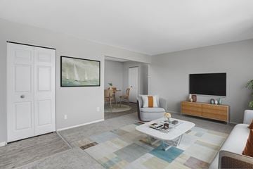 Sterling Heights apartment for rent - A living room with a couch, chair, and a painting on the wall.