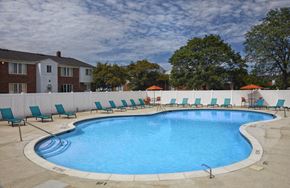 Warren apartment for rent - A large outdoor swimming pool surrounded by lounge chairs and umbrellas.