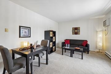 Williamston apartment for rent - A black couch with red pillows sits in a living room with a dining table and chairs.