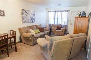 Springfield triplex for rent - a living room with couches and chairs and a dining room table