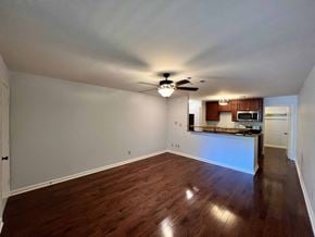 Little Rock apartment for rent - an empty living room and kitchen with wood floors and a ceiling fan
