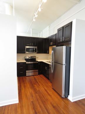 Little Rock apartment for rent - a kitchen with black cabinets and a stainless steel refrigerator