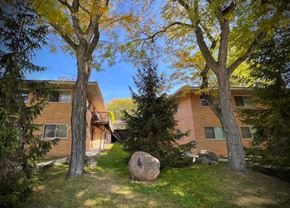 Saline apartment for rent - A large rock sits in the grass in front of a building.