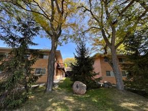 Saline apartment for rent - A large rock sits in the grass in front of a building.