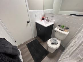 Saline apartment for rent - A bathroom with a toilet, sink, and mirror.