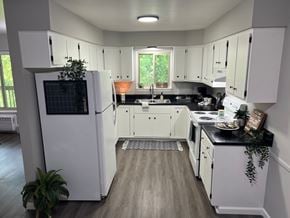 Saline apartment for rent - A kitchen with white cabinets and a black countertop.
