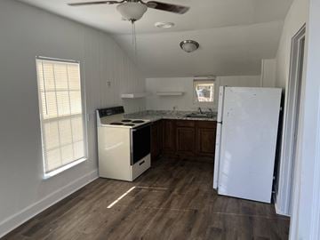 Abilene apartment for rent - A kitchen with a white refrigerator, a dishwasher, and a ceiling fan.