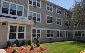 Torrington apartment for rent - a large apartment building with a yard and grass