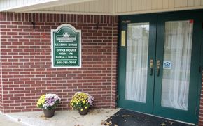 Hagerstown apartment for rent - a brick building with green doors and a sign for leasing office