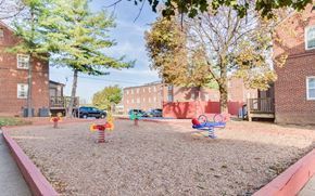 Washington apartment for rent - a playground with colorful playground toys in front of a brick building