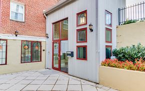 Washington apartment for rent - the front of a white building with red windows and a sidewalk