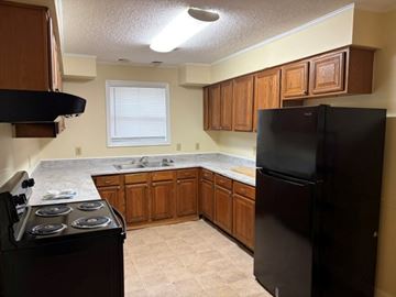 Beaufort - Available Now apartment for rent - A kitchen with a black refrigerator and a black stove top oven.
