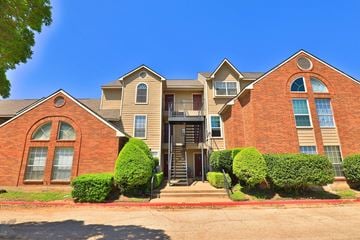 Abilene apartment for rent - A large brick house with a red door and a balcony.
