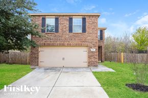 San Antonio house for rent - A brick house with a garage door and a tree in front.