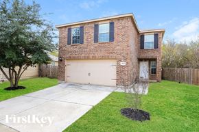 San Antonio house for rent - A brick house with a garage door and a tree in front.