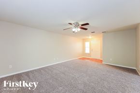 San Antonio house for rent - A carpeted room with a ceiling fan and a door.