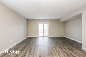 Pittsboro house for rent - A spacious room with wooden flooring and a large window.
