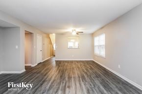 Pittsboro house for rent - A spacious room with wooden flooring and a ceiling fan.