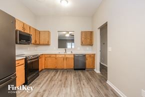 Pittsboro house for rent - A kitchen with wooden cabinets and a black refrigerator.