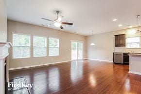 Charlotte house for rent - A spacious room with a ceiling fan and wooden flooring.