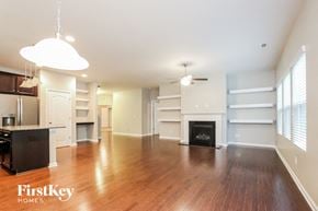 Charlotte house for rent - A spacious living room with wood flooring and a fireplace.