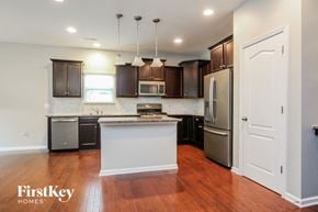 Charlotte house for rent - A kitchen with wooden floors and a white island.