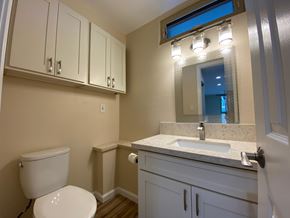 Mililani apartment for rent - A bathroom with a toilet, sink, and mirror.