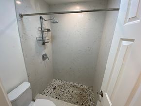 Mililani apartment for rent - A white toilet is next to a shower in a bathroom.