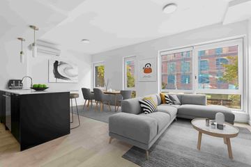 Brooklyn apartment for rent - A modern living room with a grey sofa and a black kitchen island.