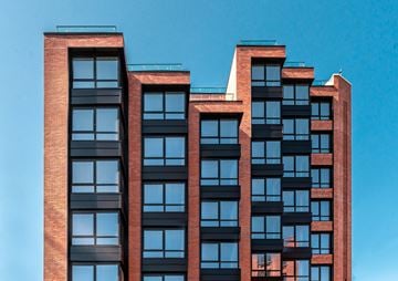 Brooklyn apartment for rent - A red brick building with black windows and balconies.