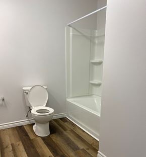 Kentville apartment for rent - A white toilet sits next to a white bathtub in a bathroom.