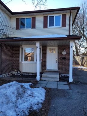 Waterloo apartment for rent - a white door on a brick house with snow on the sidewalk