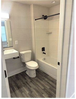 Laurel apartment for rent - A white toilet is in a bathroom with a walk-in shower.