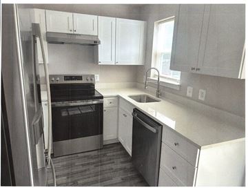 Laurel apartment for rent - A kitchen with white cabinets and a stainless steel refrigerator.