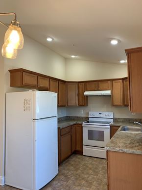 Laurel apartment for rent - a kitchen with white appliances and wooden cabinets