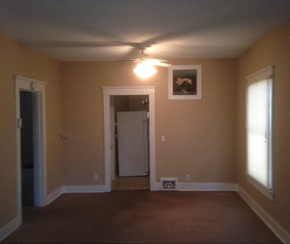 Saint Louis house for rent - an empty living room with a ceiling fan and a door to a hallway