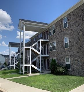 Laurel apartment for rent - A stone building with a white covered staircase.