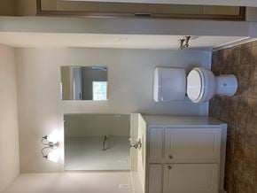 Laurel apartment for rent - A bathroom with a toilet, sink, and mirror.