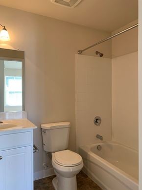 Laurel apartment for rent - A white toilet sits next to a white sink in a bathroom.