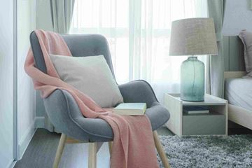 Hamilton apartment for rent - a chair with a pillow and a lamp in a room